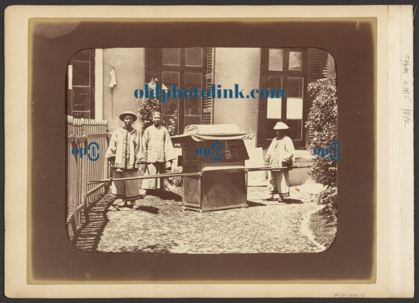 Men standing beside litter 1872