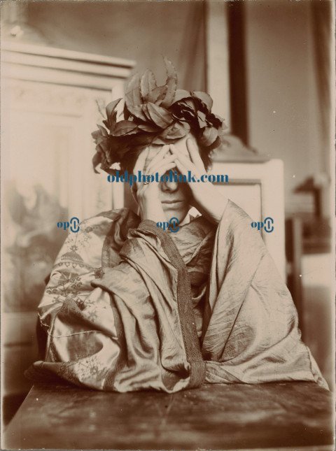 Woman leaning on a table, hands in front of her face 1902